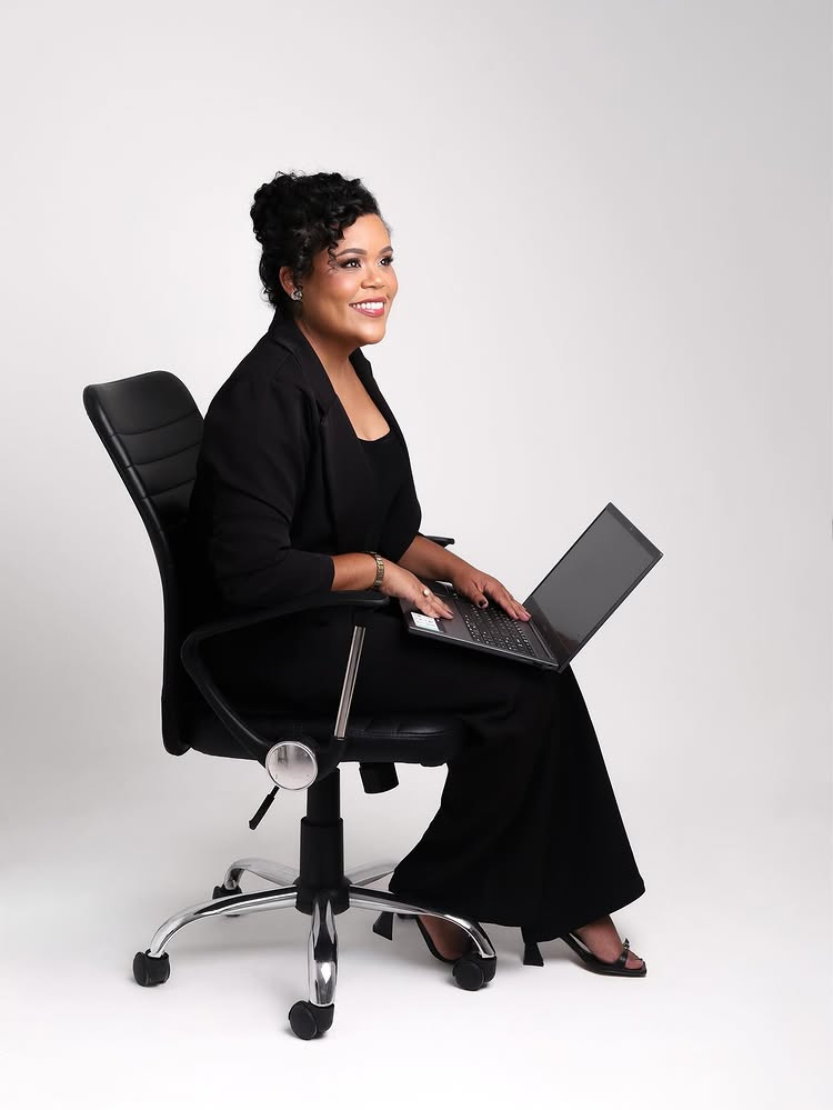 Assirleide Silva sorrindo, sentada com um notebook